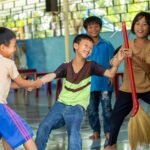 Happy children playing together in Vinh Son shelter, Kon Tum, showcasing friendship and fun.