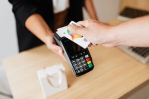 Close-up of contactless payment using a credit card at a modern POS terminal.