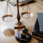 A striking image featuring a brass justice scale and gavel on a wooden desk, symbolizing law and justice.