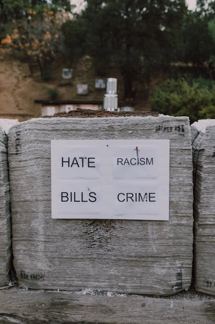 An outdoor archery target with arrows shot into words like hate and racism, promoting a message of unity.