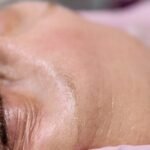 Close-up of a senior woman receiving a relaxing facial treatment in a spa setting.