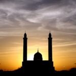 Beautiful silhouette of a mosque against a vibrant sunset sky, highlighting its architectural elegance.