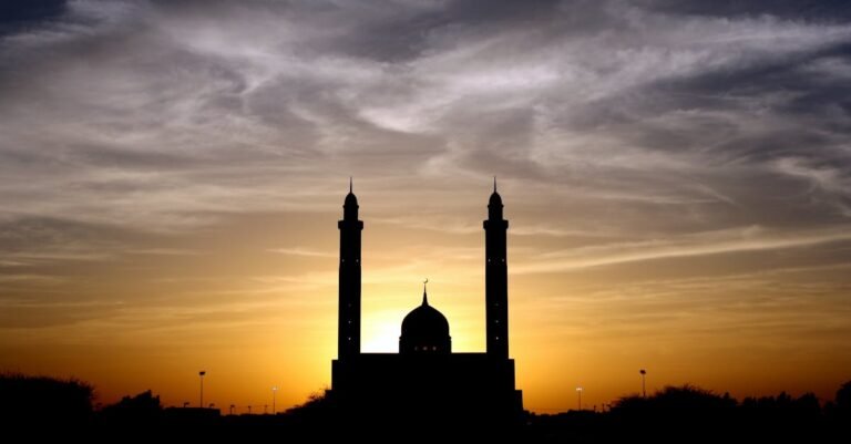 Beautiful silhouette of a mosque against a vibrant sunset sky, highlighting its architectural elegance.