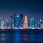 Captivating night view of Doha's illuminated skyline reflecting over the water.